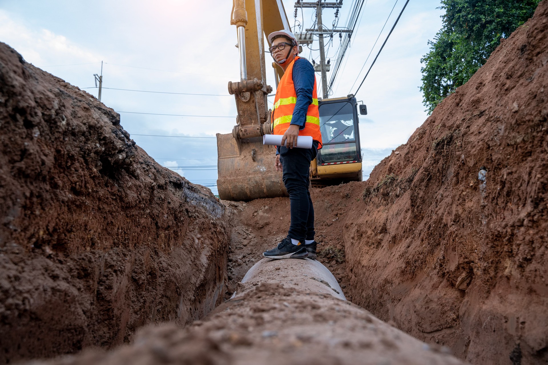 Engineer wear safety uniform examining excavation water supply or sewer pipeline